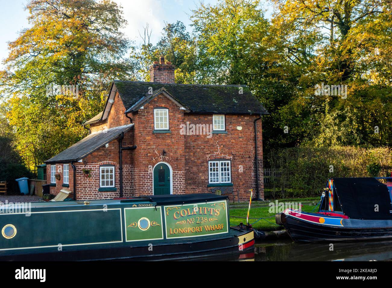 Alte funktionierende Kanalschromper von Longport Wharf vertäuten auf dem Shropshire Union Kanal vor einem Kanalhaus in Nantwich Chethire Stockfoto