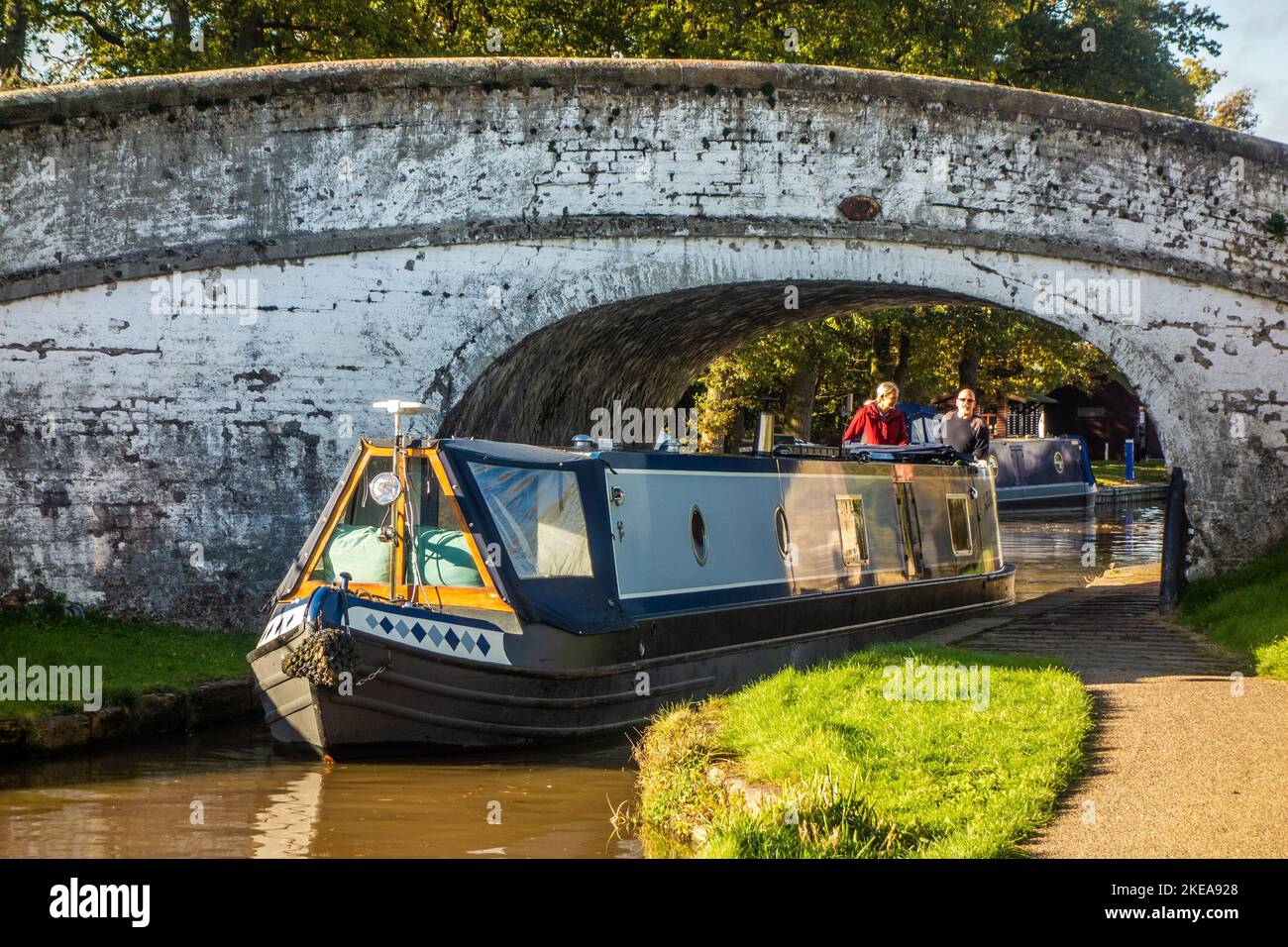 Kanal-Schmalboot unter einer Brücke auf dem Shropshire Union Kanal bei Nantwich Chethire England Stockfoto