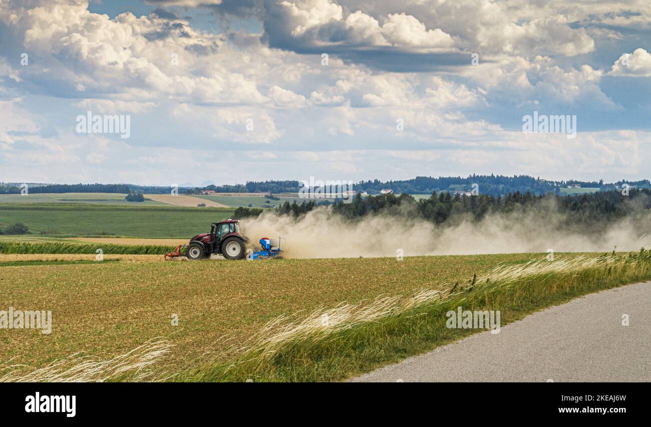 Landwirt, der ausgetrocktes Feld kultiviert und Staub aufbaut, Deutschland, Bayern, Isental Stockfoto