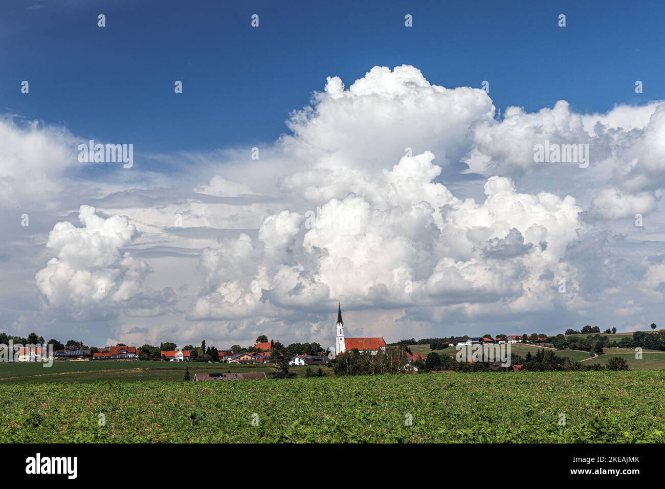 Cumulus congestus Wolken über einem Dorf mit spätromantischer Kirchturm, Deutschland, Bayern, Alpenvorland, Kirchdorf/Haag Stockfoto