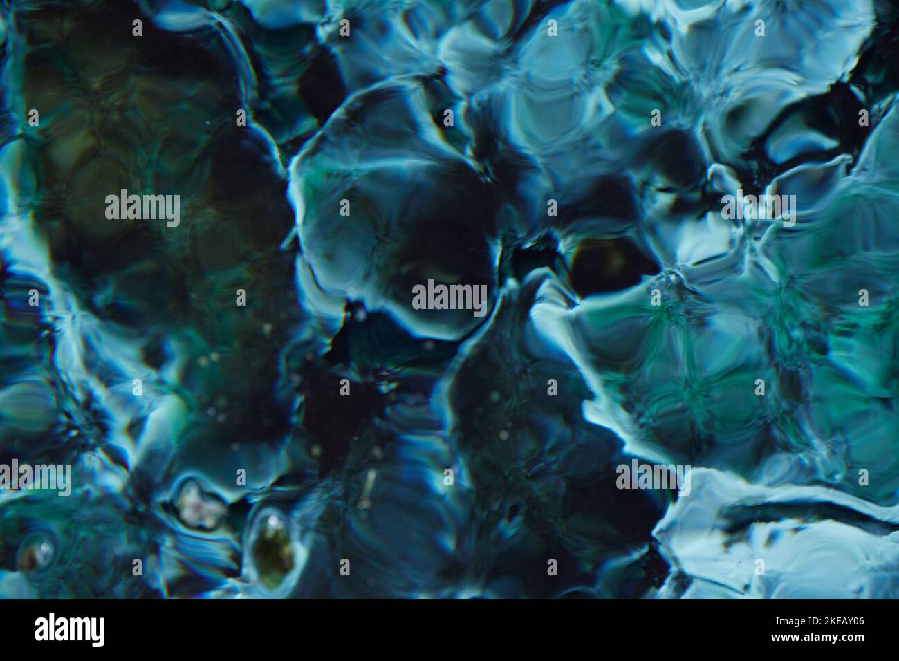 Eine abstrakte Wasserstruktur. Türkisfarbene, transparente, wellige Oberfläche eines Teiches Stockfoto