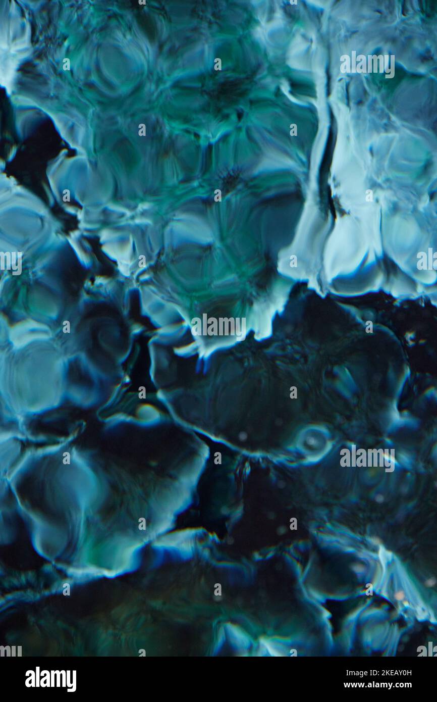 Eine abstrakte Wasserstruktur. Türkisfarbene, transparente, wellige Oberfläche eines Teiches Stockfoto