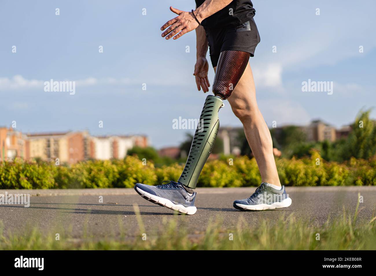 Low-Angle-Ansicht auf behinderte junge Mann mit prothetischen Bein zu Fuß entlang der A-Weg im Park - Gesundheitsversorgung und Menschen Lifestyle-Konzept Stockfoto
