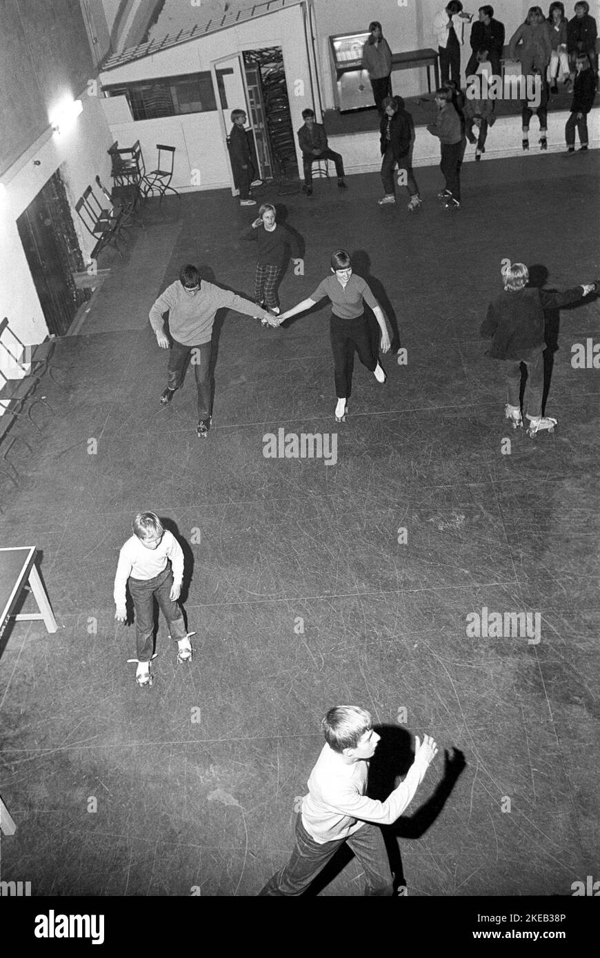 Roller Skate Spaß in der 1960s. Das Innere der Rollerdisco mit den Leuten Rollschuhlaufen. Rollschuhlaufen begann zu dieser Zeit und im Laufe des Jahres 1970s zu Trend, als Rollschuhlaufen mit Disco-Musik und Rollerdiscos assoziiert wurde. Eine Jukebox ist sichtbar und spielte die leicht tanzbare Disco. Schweden 1967 Conard Ref. 5419 Stockfoto