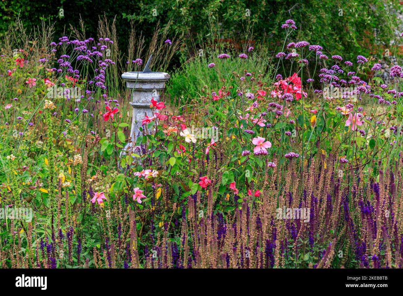 Farbenfrohe Blumen und eine Sonnenuhr im ummauerten Garten des Heale House - einem aus Backsteinen gebauten Herrenhaus aus dem 17.. Jahrhundert in Middle Woodford, Wiltshire, England, Großbritannien Stockfoto