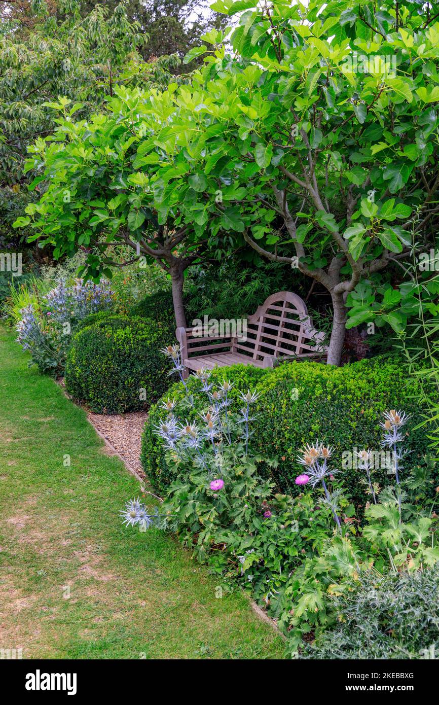 Eine hölzerne Lutyens Bank im ummauerten Garten des Heale House - ein 17. Jahrhundert Backstein Herrenhaus in Middle Woodford, Wiltshire, England, Großbritannien Stockfoto