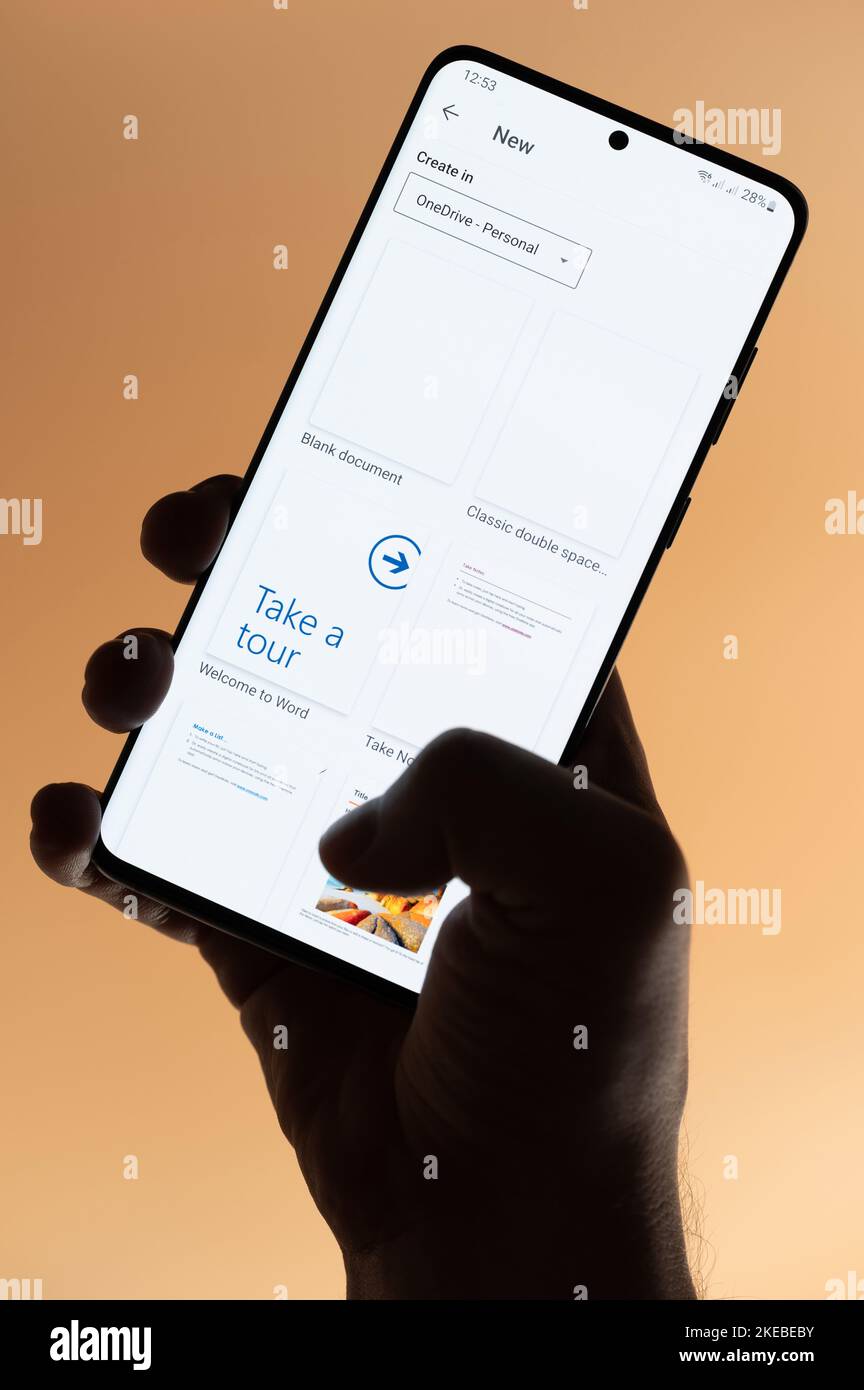 New york, USA - 4. November 2022: Microsoft Word-App auf Smartphone verwenden, das auf braunem Hintergrund isoliert in der Hand hält Stockfoto