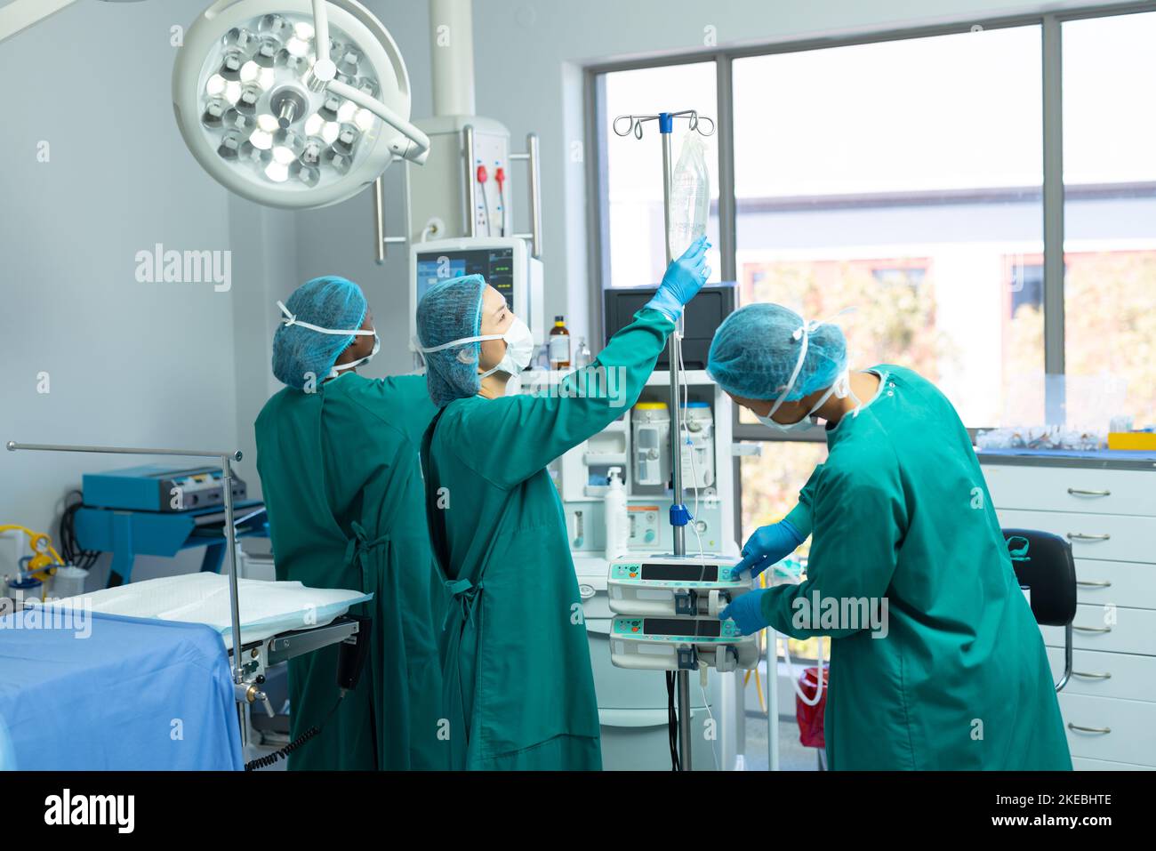 Diverse Chirurgietechnikerinnen prüfen und richten Geräte im Operationssaal ein Stockfoto