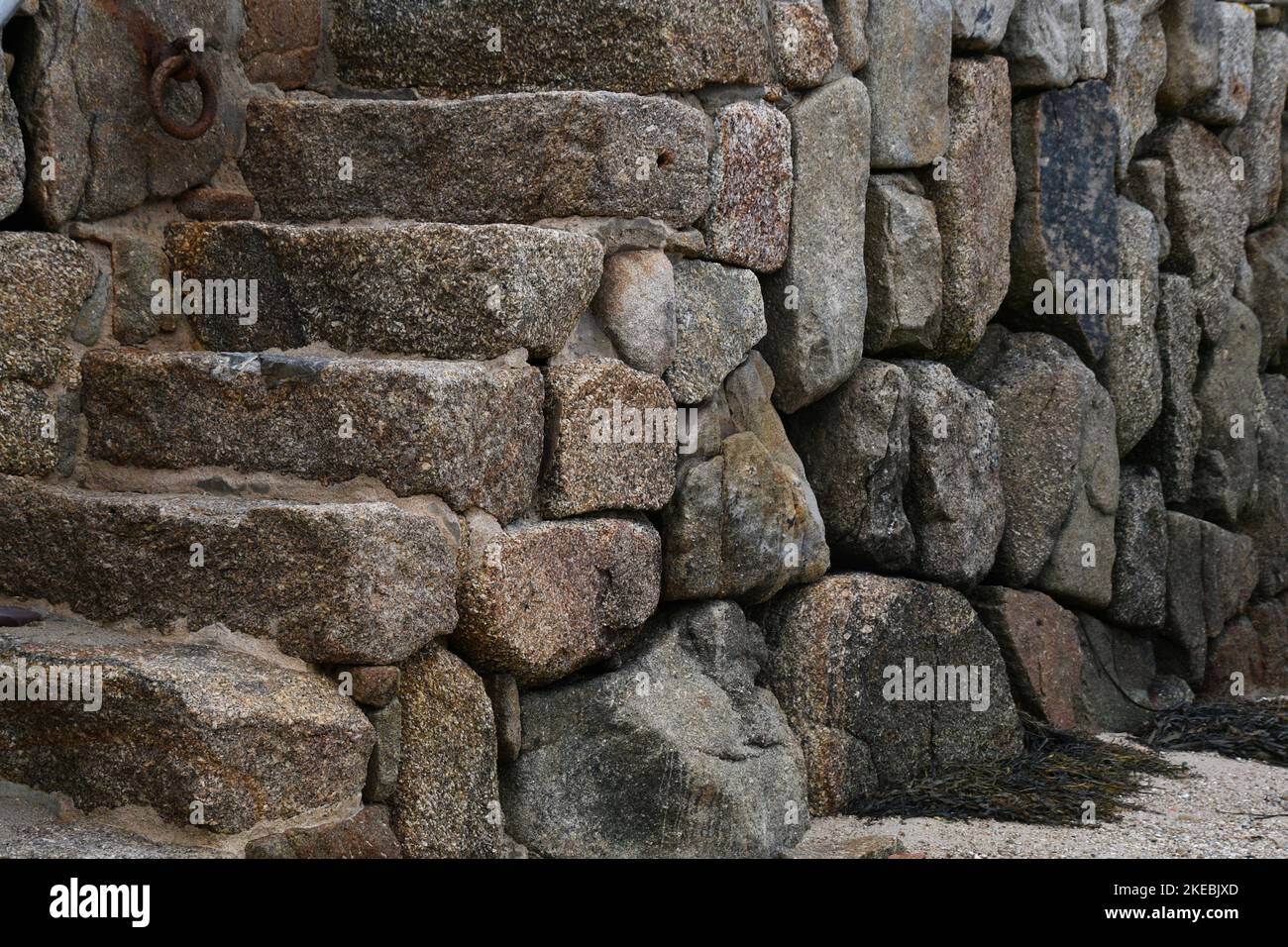 Granitblöcke bilden den Kai und die Stufen des Hafens in New Grimsby auf der Insel Tresco in den Isles of Scilly archepelago vor der Küste von Cornw Stockfoto