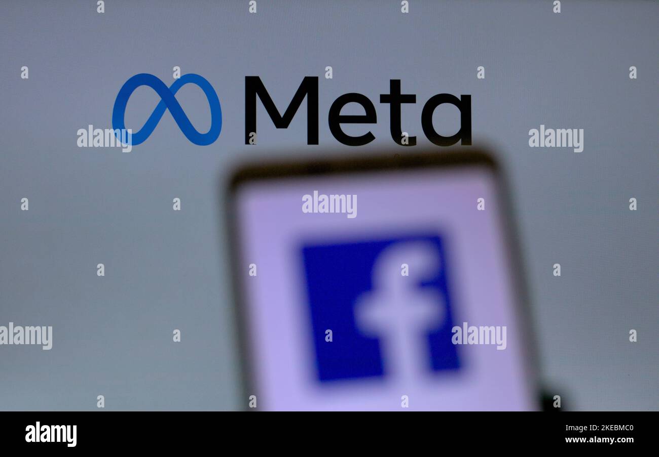 Verwaist fokussieren mobilen Bildschirm vor einem großen Bildschirm mit META-Logo. Stockfoto