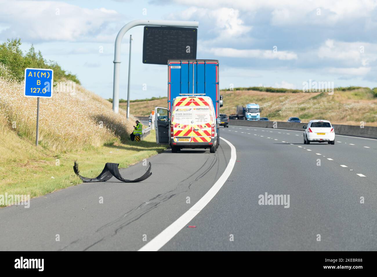 Umgefüllter Reifen (Runderneuerungsreifen) auf der harten Schulter von A1(M) neben Pannenhubwagen und Rettungswagen – Vereinigtes Königreich Stockfoto