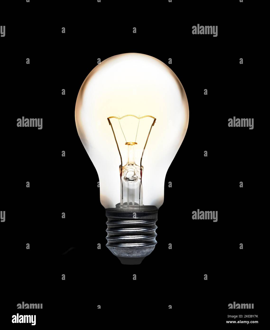 Glühlampe mit glühendem Glühfaden, isoliert auf schwarzem Hintergrund Stockfoto