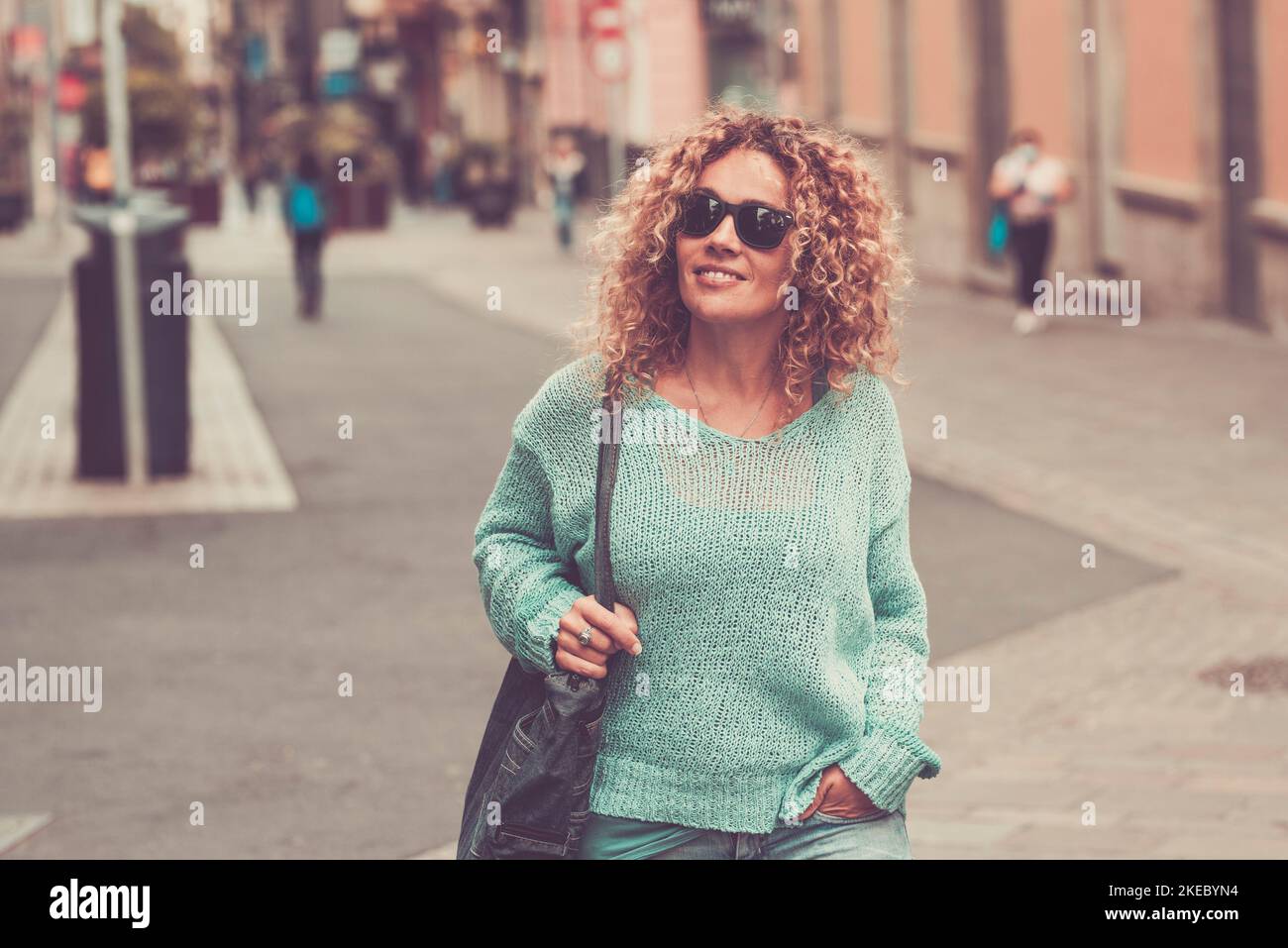 Lächelnd attraktive weibliche Touristen, die auf der Straße nach Geschäften Ausschau halten. Stadttourismus Konzept Lifestyle. Eine glückliche Frau, die im Stadtzentrum Outdoor-Aktivitäten in Sonnenbrillen genießt Stockfoto