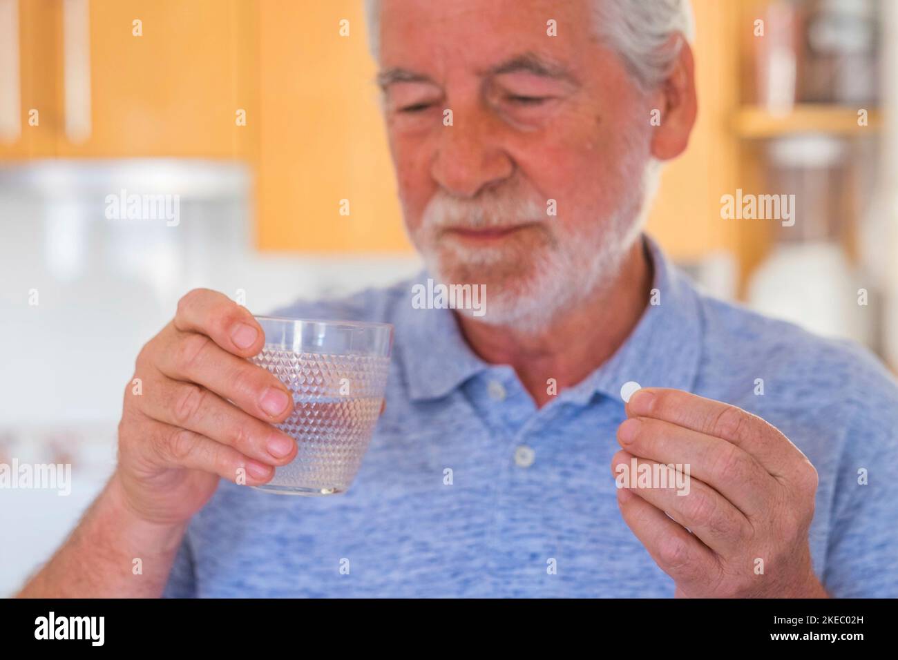 Nahaufnahme und Porträt eines reifen Mannes oder Senior Taking Arzneimittel und Kissen mit einem Glas Wasser - krank Und Schmerzen Rentner Stockfoto