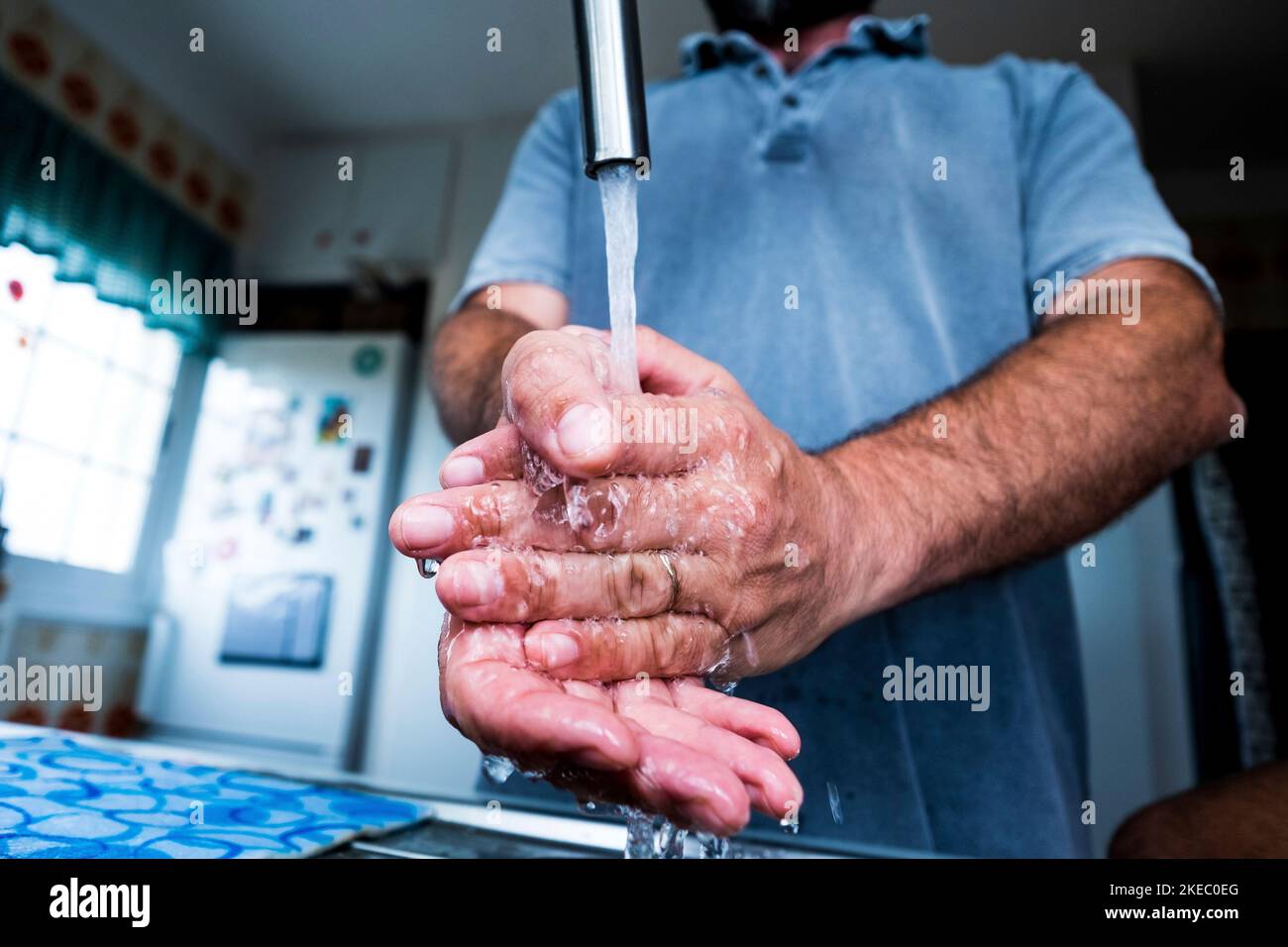 Nahaufnahme des Mannes Reinigung und Waschen der Hände in der Küche, um Keime und Bakterien zu kil - Prävention covid-19, Coronavirus oder jede Art von Krankheit oder Grippe Stockfoto