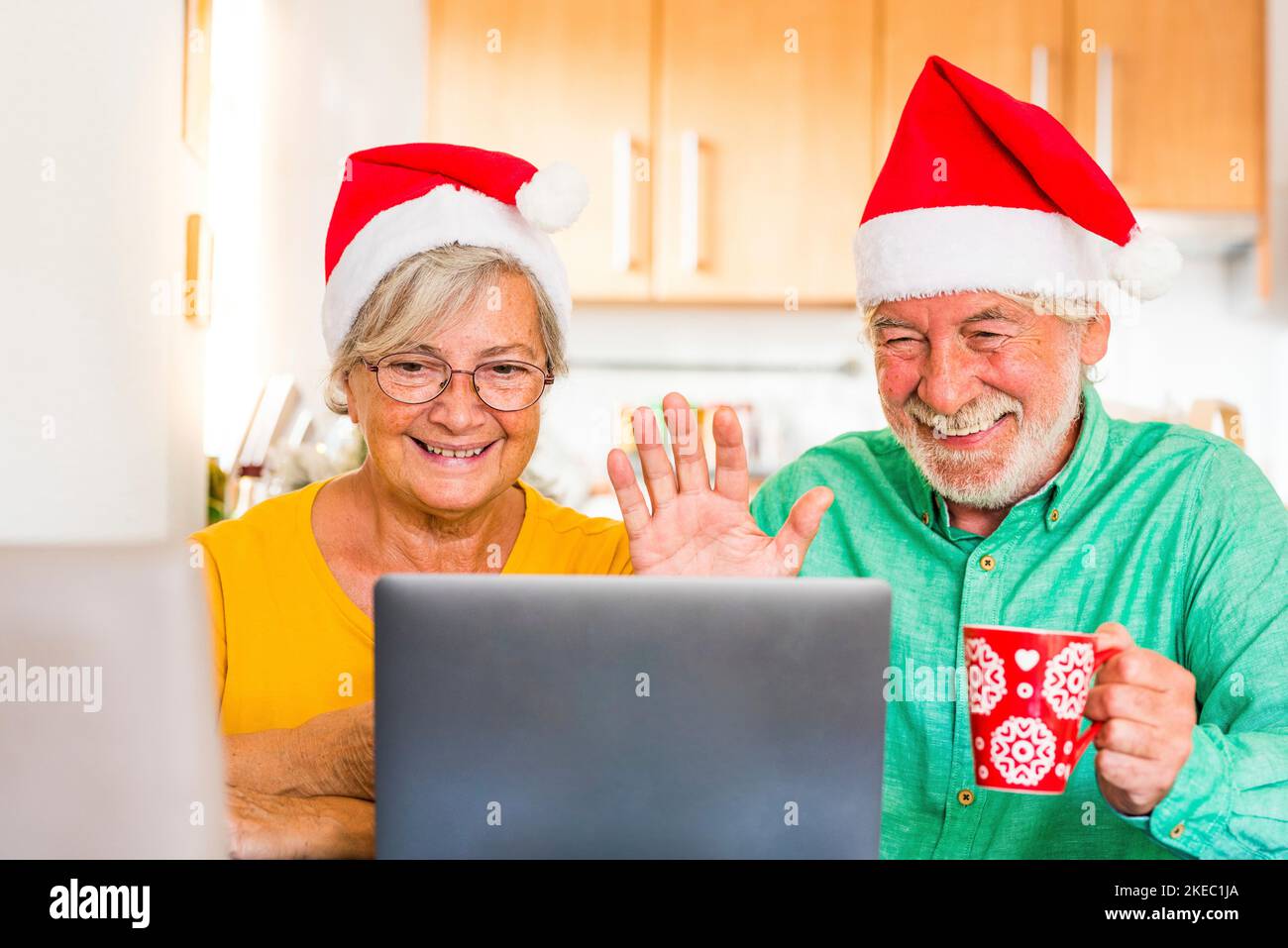 Zwei Senioren rufen ihre Familie zu Hause an und feiern weihnachten mit einem Laptop Stockfoto
