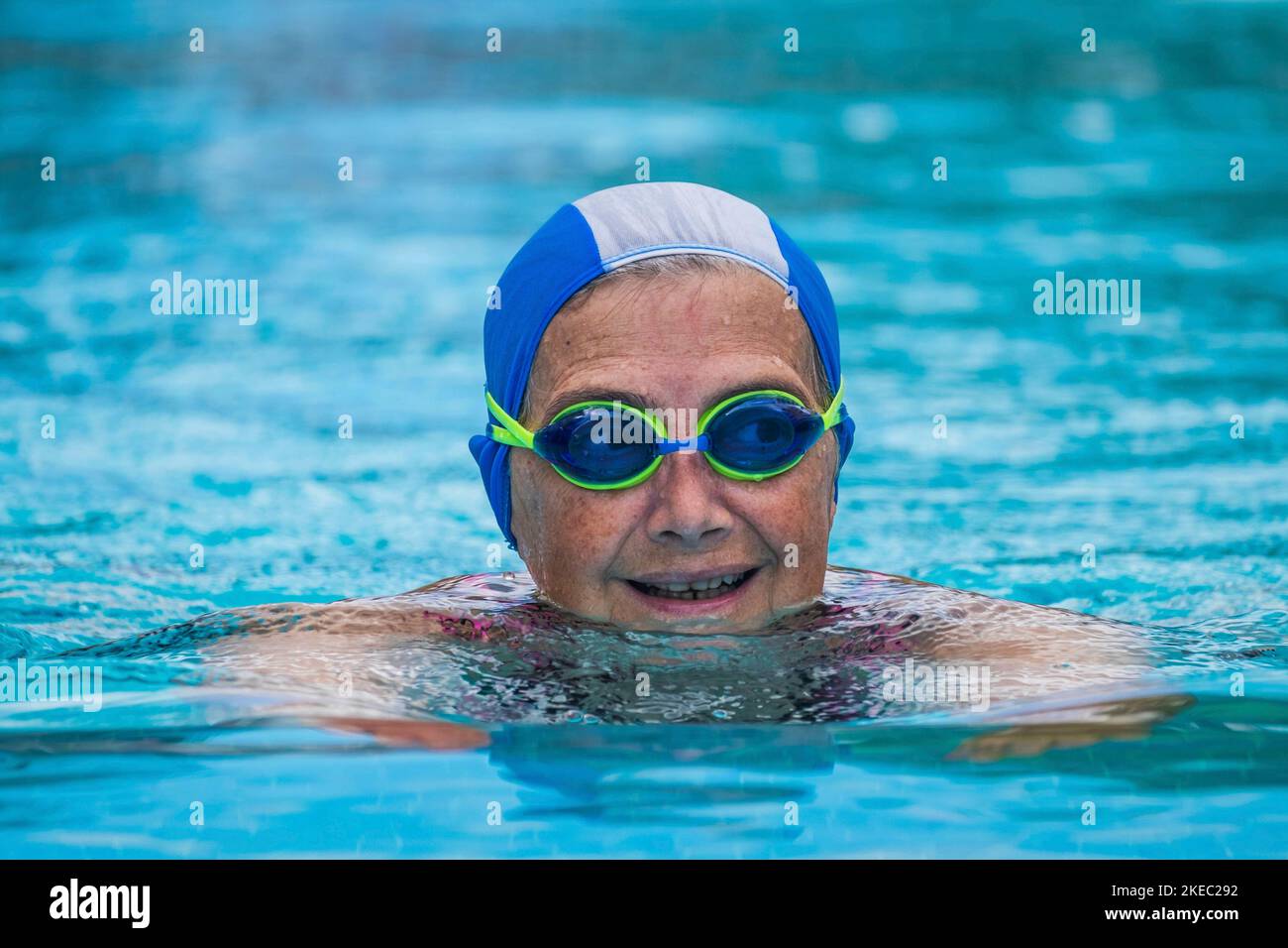 Eine reife Frau schwimmt am Pool im Wasser - aktiv Senior tun Bewegung und mit einer Fitness-und Gesunder Lebensstil Stockfoto
