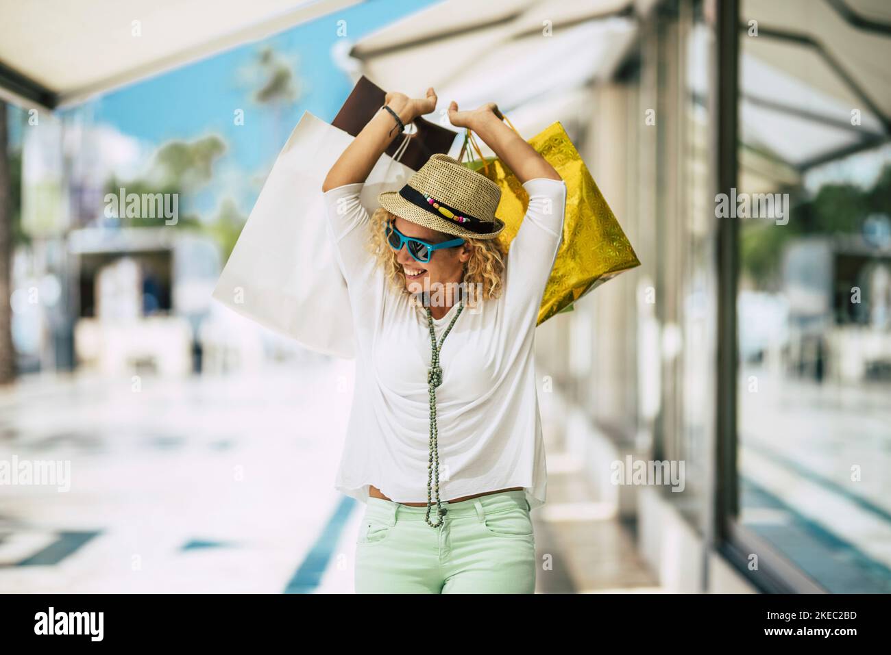 Eine junge und schöne Frau, die Geschenke und Kleidung kauft und im Einkaufszentrum im Freien einkaufen geht Stockfoto