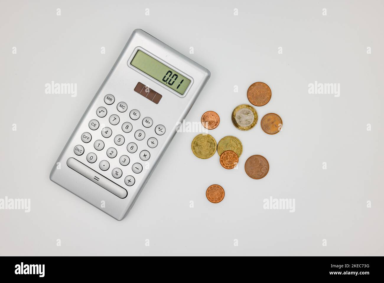 Studioaufnahme eines Rechners mit Euro- und Cent-Münzen als Zeichen der Armut in der Energiekrise Stockfoto