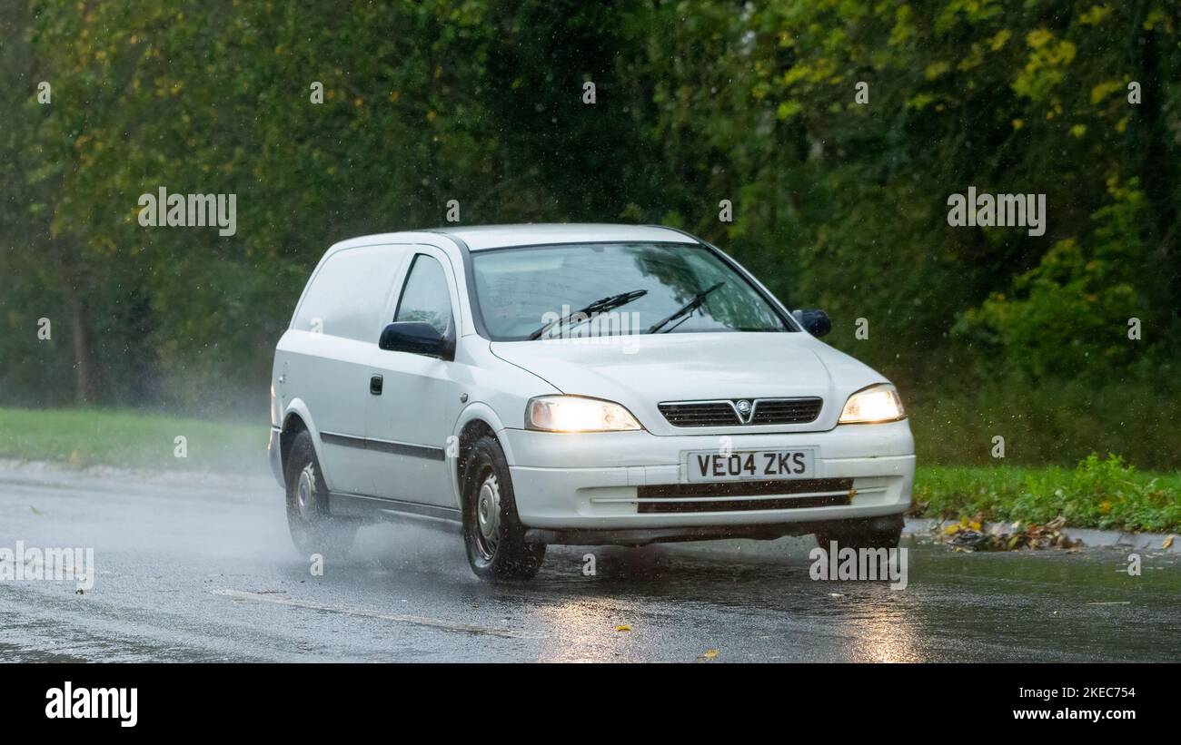 2004 weißer Vauxhall Astra Van, der im Regen auf einer nassen Straße fährt Stockfoto