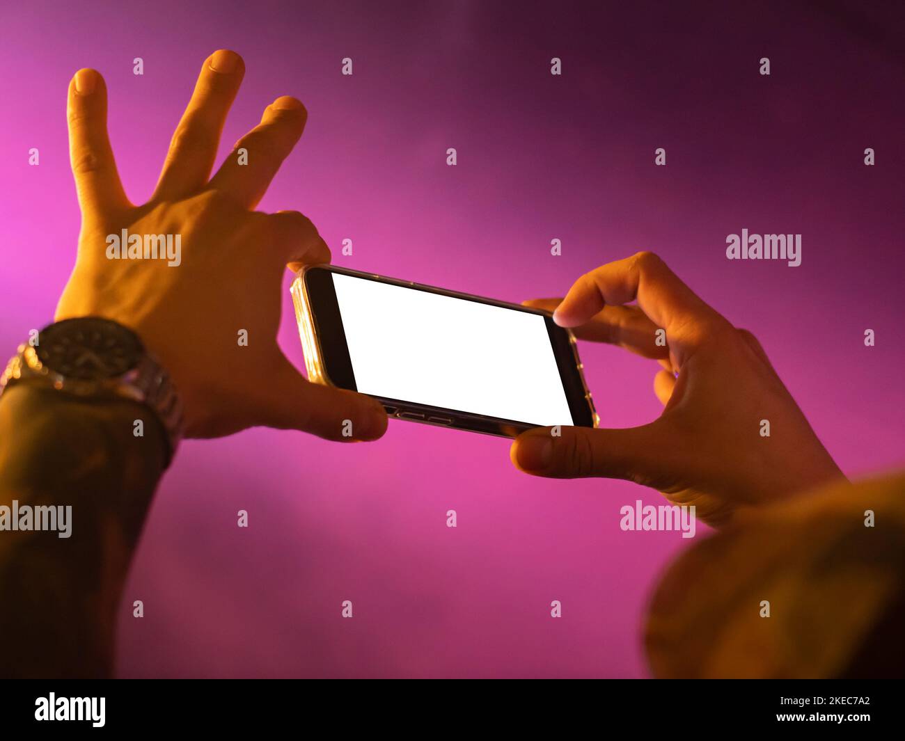 Filmen auf einer Party mit einem Mobiltelefon. Der Smartphone-Bildschirm ist für die Verwendung als Kopierplatz leer. Das leere Display kann ausgetauscht werden. Stockfoto