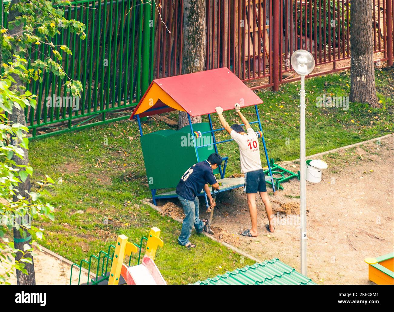 Junge asiatische Gastarbeiter, die auf dem Kindergarten-Spielplatz arbeiten Stockfoto
