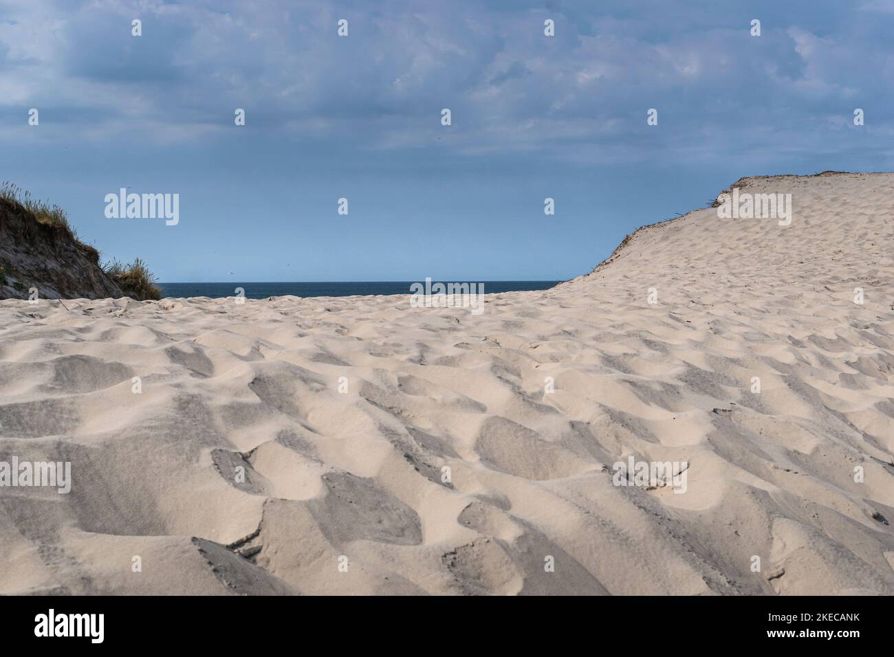 Ein breiter, verlasser Sandstrand mit himmelblauem Himmel in Dänemark. Stockfoto