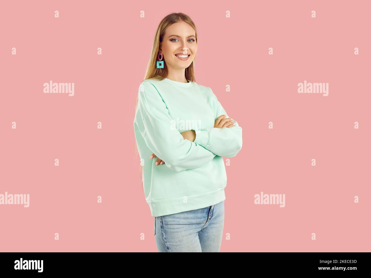 Studio Porträt von schönen lächelnden jungen Frau in stilvollen Freizeitkleidung auf rosa Hintergrund. Stockfoto