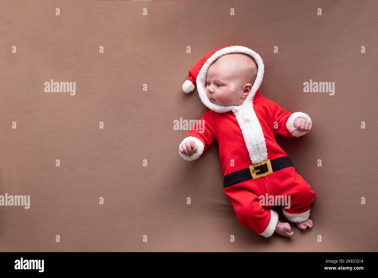 Neugeborenes Mädchen in weihnachtsmann Kostüm gähnend müde gekleidet. Stockfoto