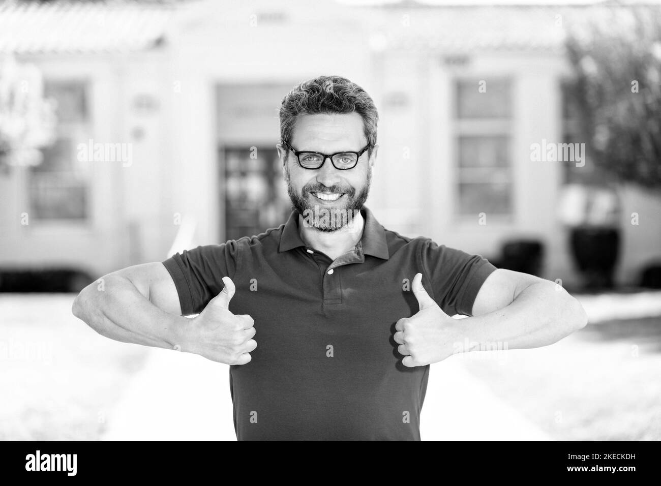 Glücklicher Nerd Mann in Brille zeigt Daumen nach oben Geste, perfekte Vision Stockfoto