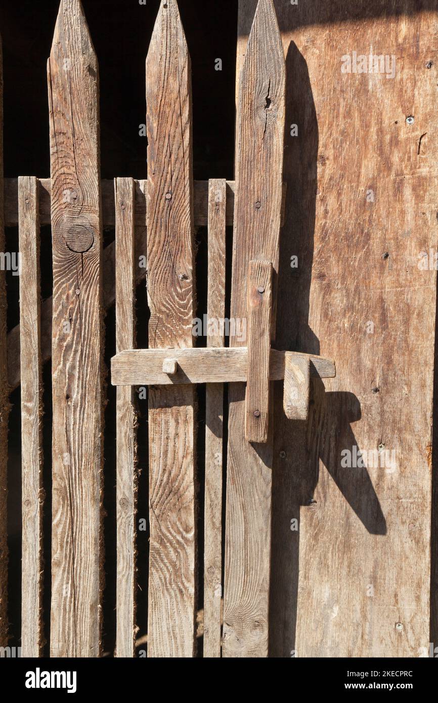 Einfache Holzbar an einer Stalltür im Südtiroler Ultental Stockfoto