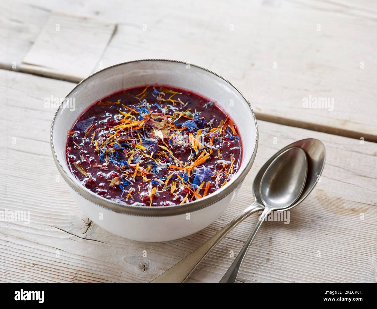 ayurvedische Küche, Chutney mit dunklen Früchten in einer hellen Schale auf einem hellen Holztisch Stockfoto