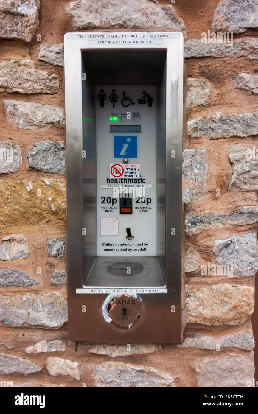 Elektronische Toilette Zahlstelle an einer öffentlichen Toilettenwand in viel Wenlock, Shropshire, England. Stockfoto