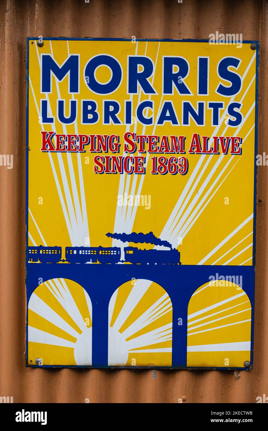 Antik Morris Lubricants Weißblech Werbung Zeichen. Zug geht über Viadukt. Blau auf gelb. Dampf am Leben erhalten seit 1869. Stockfoto
