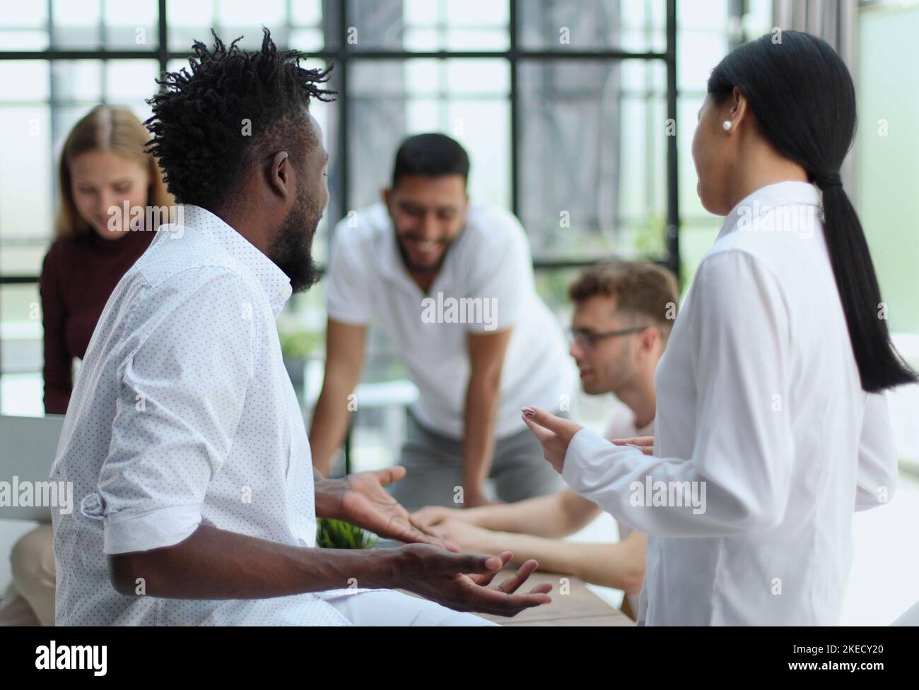 Willkommen in unserem Team, das sich während der Arbeit im Kreativbüro die Hände schüttelt Stockfoto