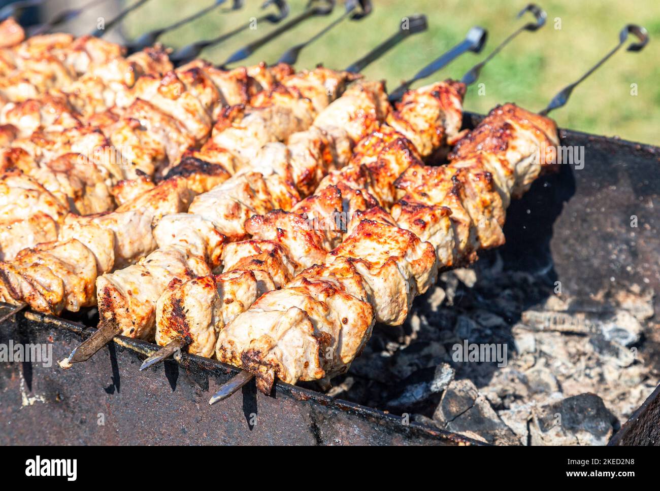 Kochen Sie traditionelle appetitliche heiße Schischebab oder Schaschlik auf Metallspießen Stockfoto