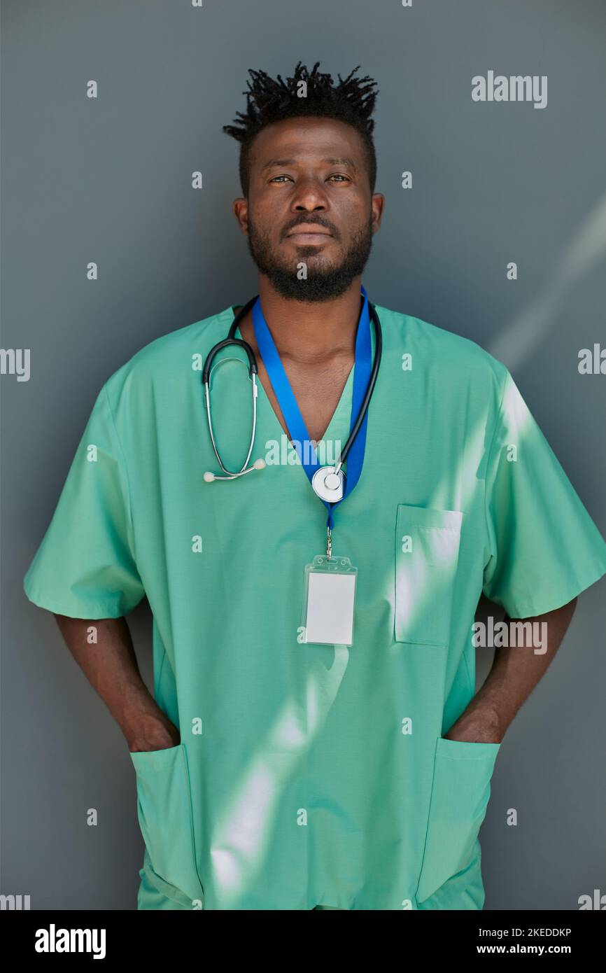 Porträt eines jungen afroamerikanischen Arztes vor grauem Hintergrund Stockfoto