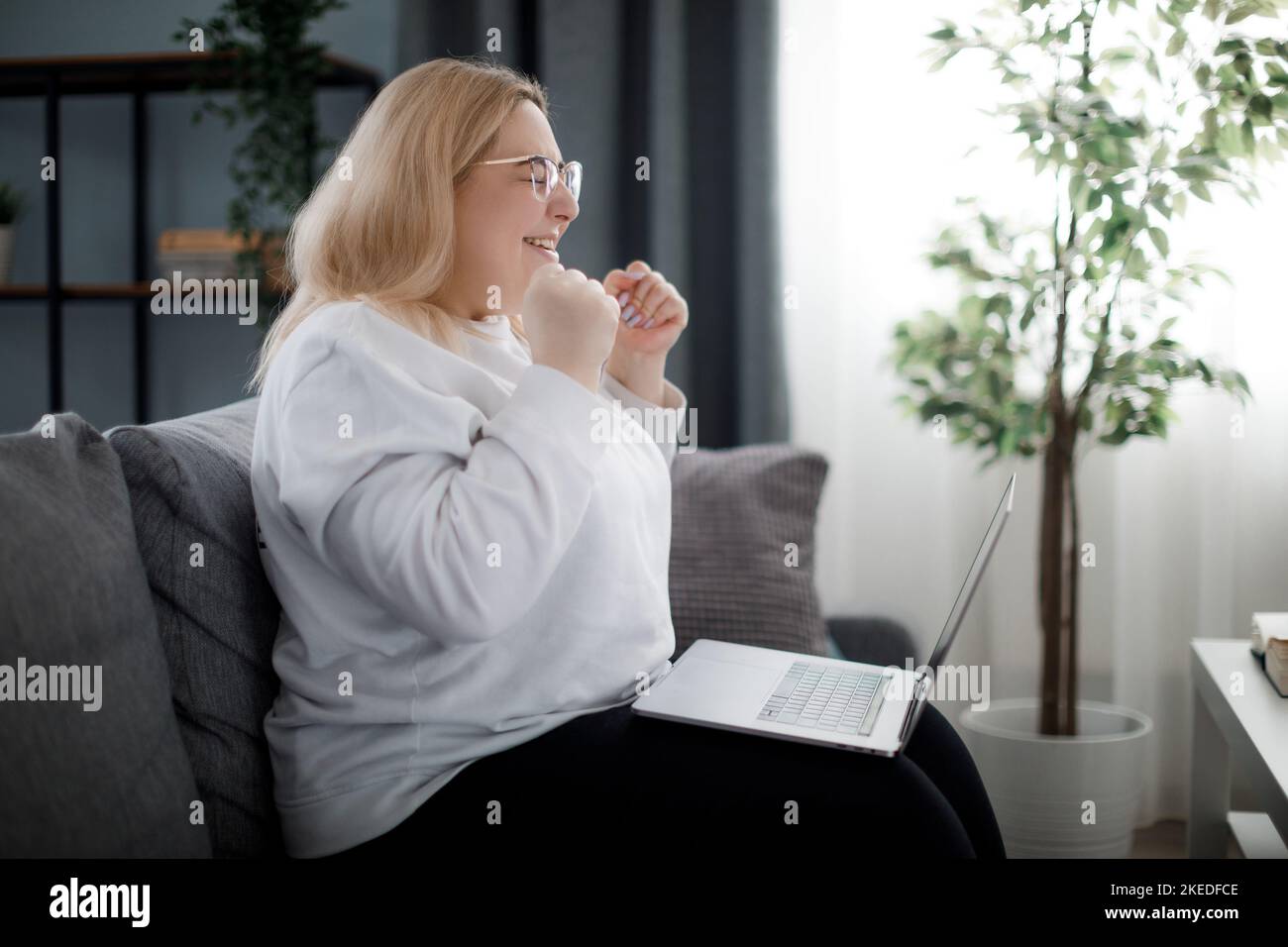 Frau mit guten Nachrichten auf dem Laptop Stockfoto