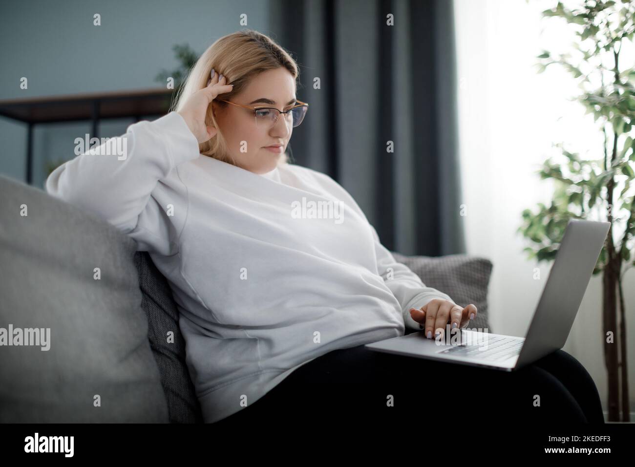 Fokussierte Frau mit Laptop Stockfoto