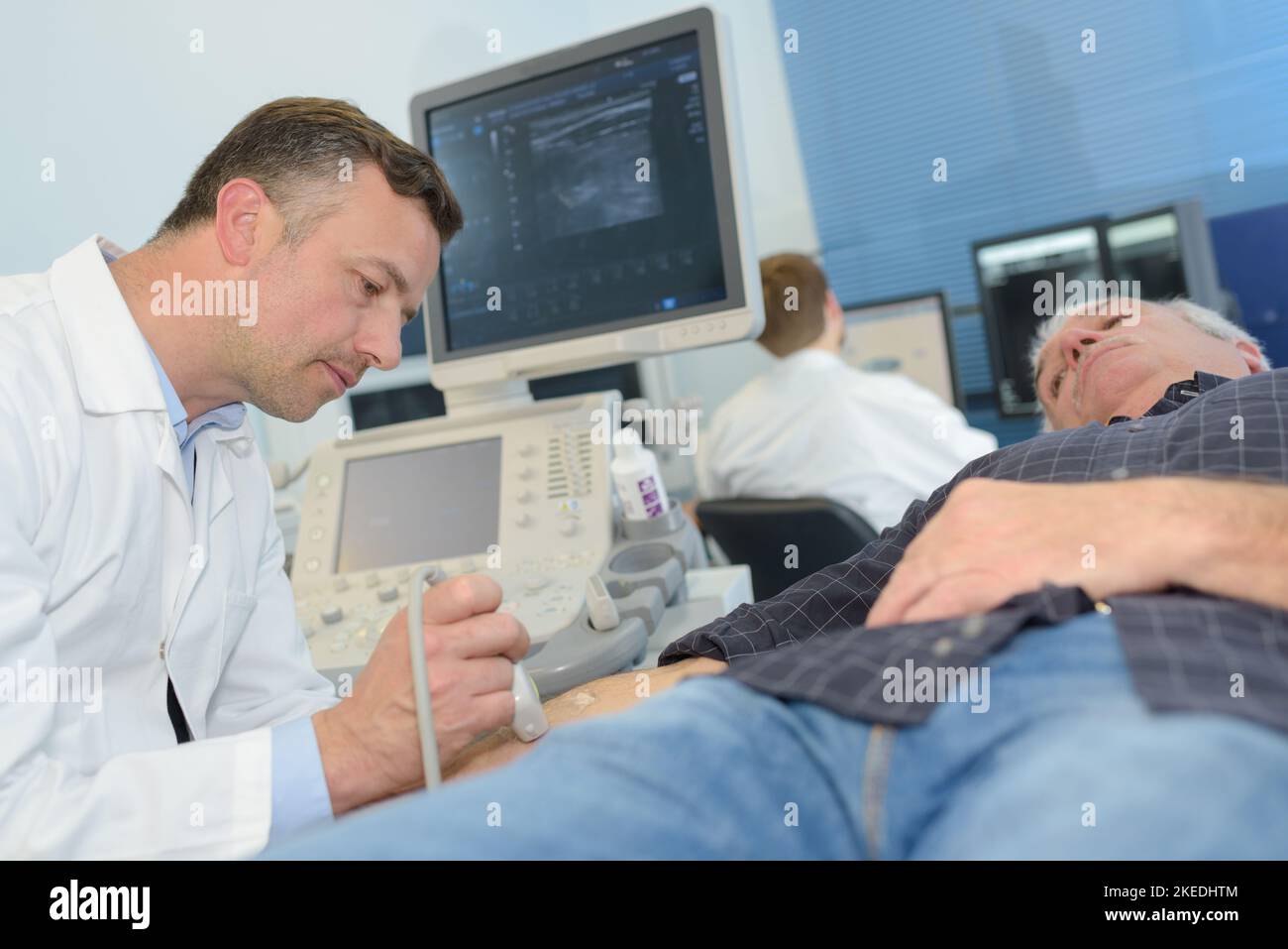 Arzt mit männlichen Patienten arm Echographie Stockfoto