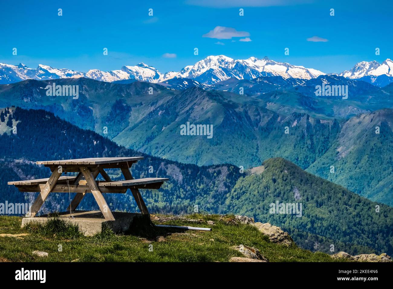 Blick auf die schneebedeckten Pyrenäen und einen Picknicktisch auf dem Gipfel des Tuc de L'Etang im Süden Frankreichs Stockfoto