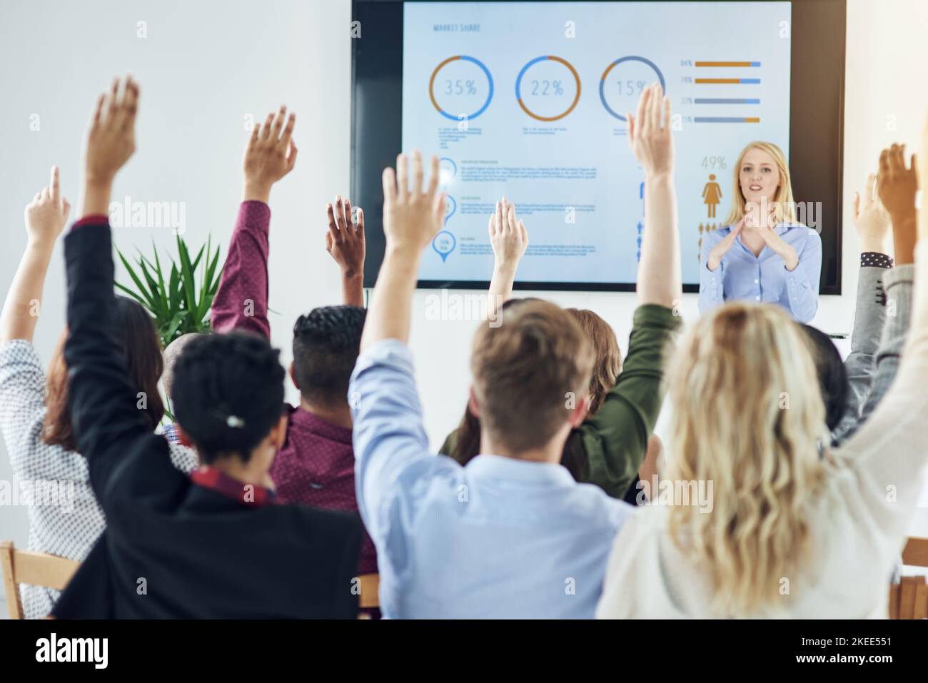 Heben Sie Ihre Hände für das Lernen Opportunites. Eine Gruppe von Geschäftsleuten heben ihre Hände in einer Klasse. Stockfoto