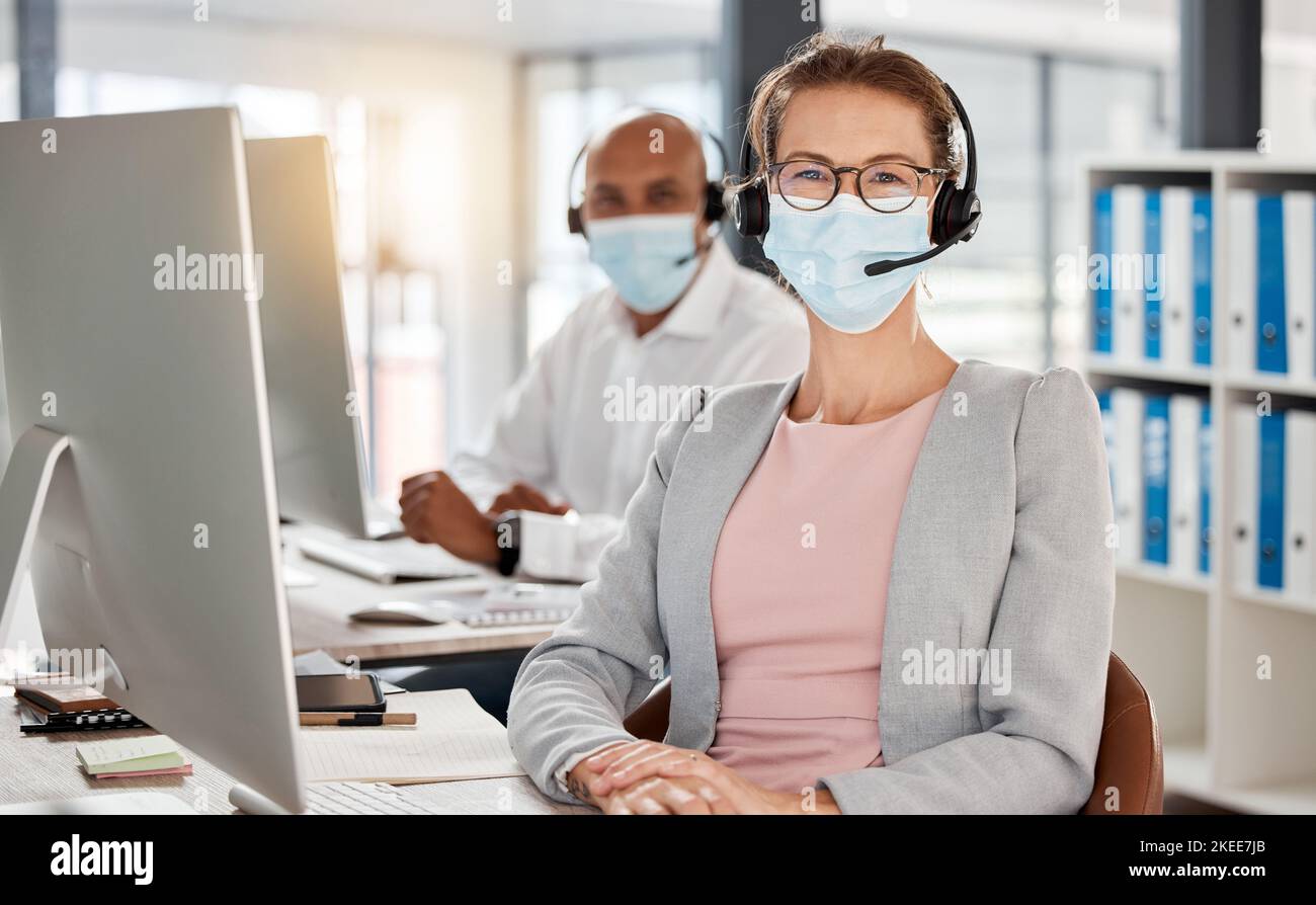 Covid, Callcenter und Portrait im Büro mit medizinischer Maske für Sicherheit, Gesundheit und Virenschutz am pc. Berater, Telemarketing und Stockfoto