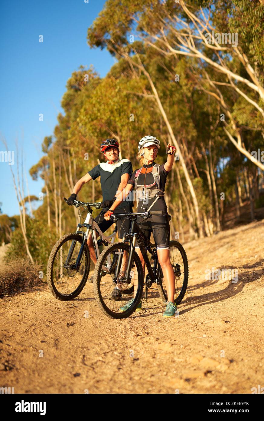 Krank Rennen Sie zu diesem Punkt. Eine Frau zeigt auf etwas, während aus für eine Radtour mit ihrem Freund. Stockfoto