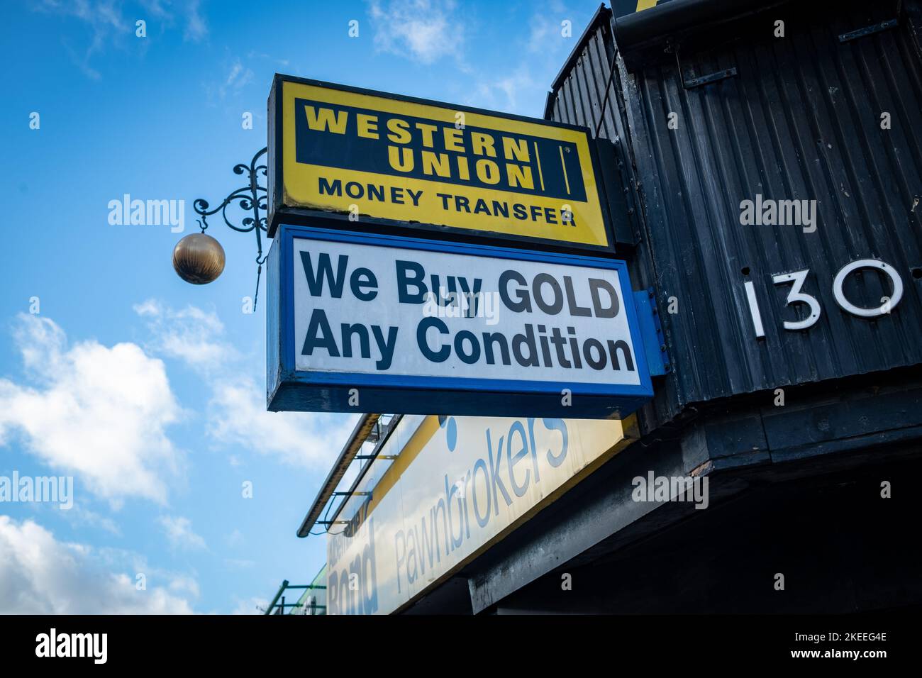 London - November 2022: WESTERN Union und wir kaufen Gold-Schilder vor einem alten Pfandrohhändler in West Ealing Stockfoto