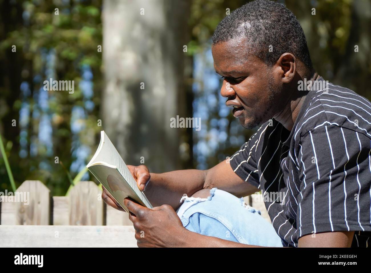 Nahaufnahme eines afrikanischen Mannes, der ein Buch liest Stockfoto