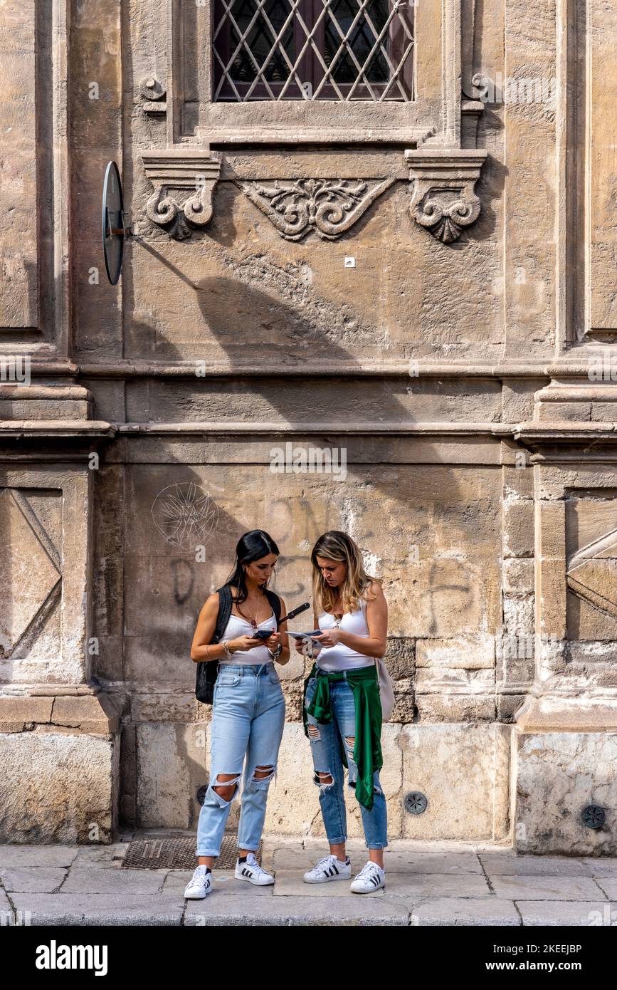 Zwei junge Frauen, die sich Eine Tourist Map ansehen, Palermo, Sizilien, Italien. Stockfoto