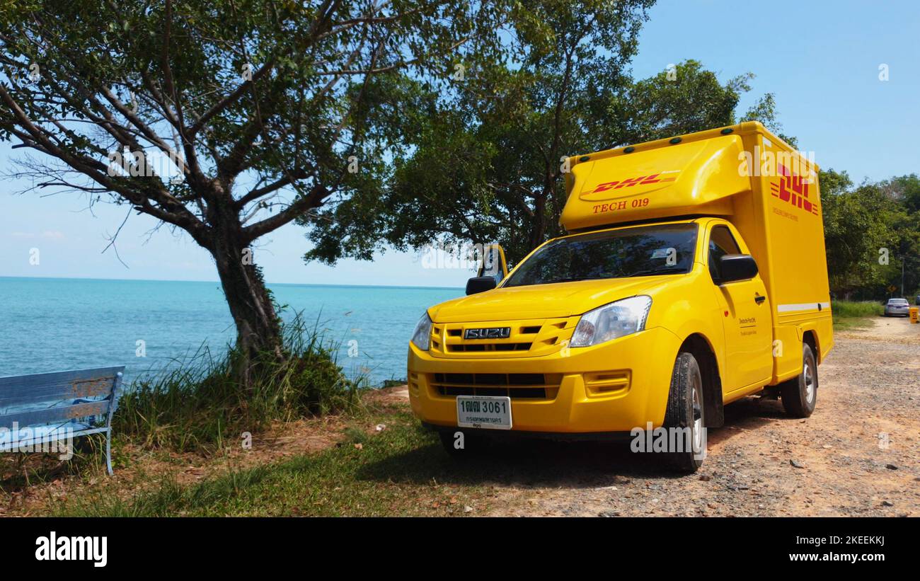 KOH CHANG, TRAT, THAILAND – 11. NOVEMBER 2022: DHL-LIEFERWAGEN. DHL ist weltweit Marktführer in der Logistikbranche. Das Auto ist am Strand. Der Fahrer ruht sich an sonnigen Tagen auf einer tropischen exotischen Insel aus Stockfoto