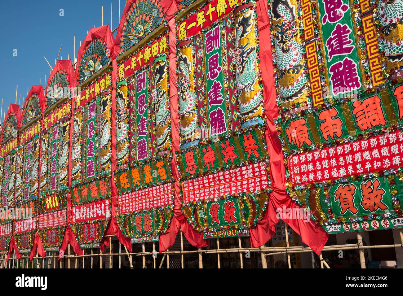 Bunte Blumentafeln (‘fa paai’) schmücken die Hauptstraße der Stadt kam Tin für das zehnjährige Da Jiu Festival, New Territories, Hong Kong, 2015 Stockfoto