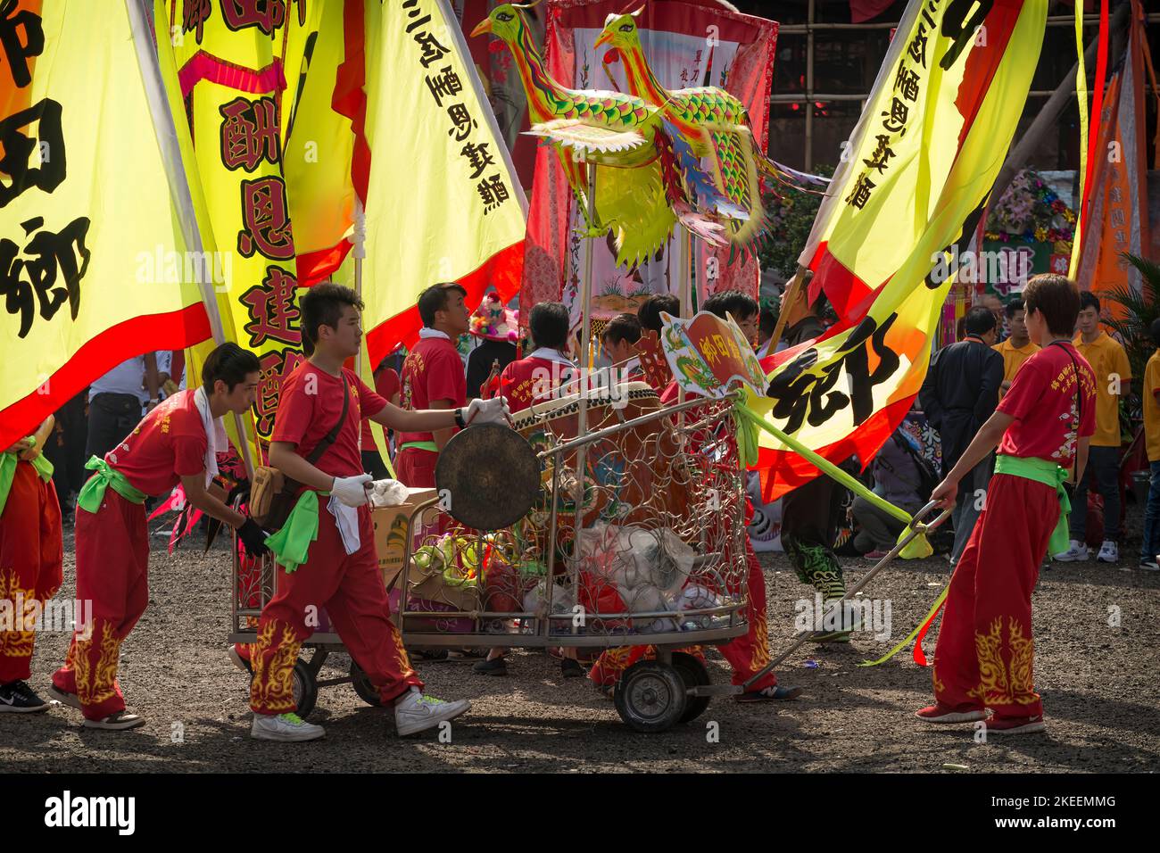 Die Mitglieder des Drachentanzteams ziehen einen Wagen mit einer zeremoniellen Trommel, gong und Wimpern auf dem zehnjährigen Festival Da Jiu, kam Tin, Hongkong, 2015 Stockfoto